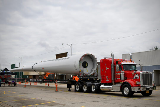 A truck hauls in a turbine blade for the Everly Days Festival.