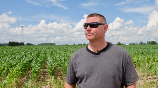 John Hardman gazes out at the wind turbines dotting his family's farm.