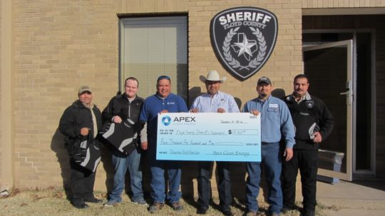 Apex Asset Management employees present Floyd County Sheriff's Office deputies with a donation that will be used to purchase needed equipment.