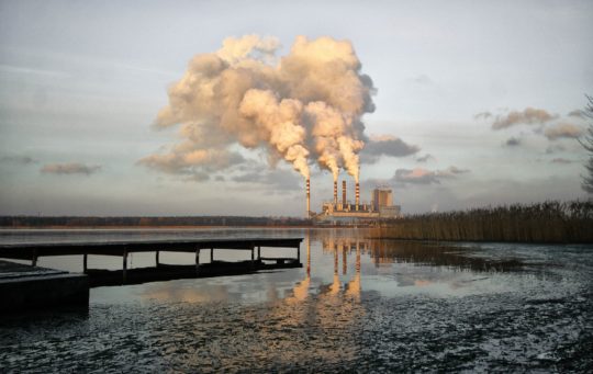 An industrial plant spews emissions alongside a body of water. Coal-fired power plants across the United States are responsible for 36.5 trillion gallons of freshwater withdrawals each year.