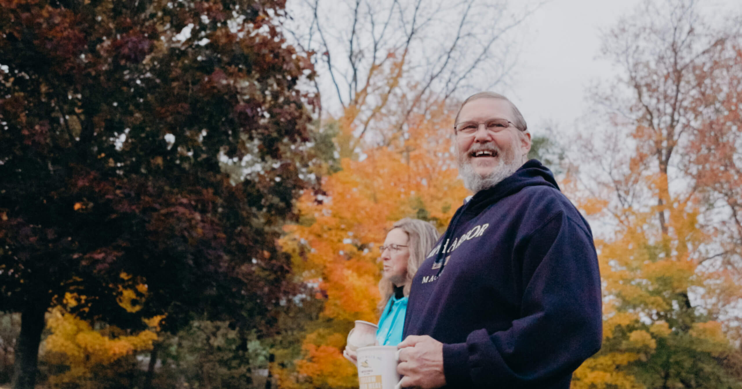 couple walking, drinking coffee, and smiling