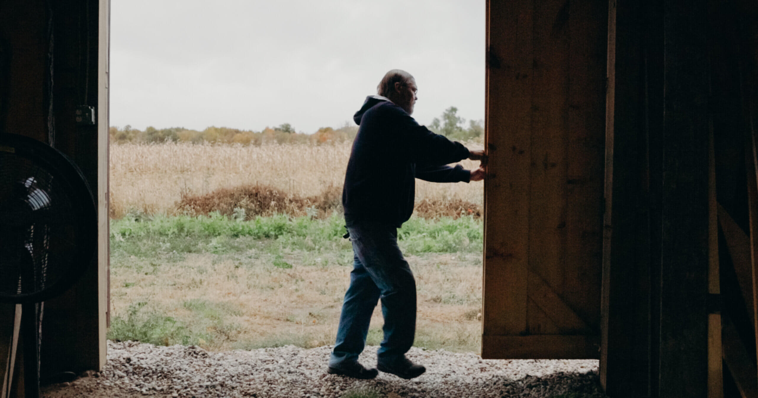 man closing barn door