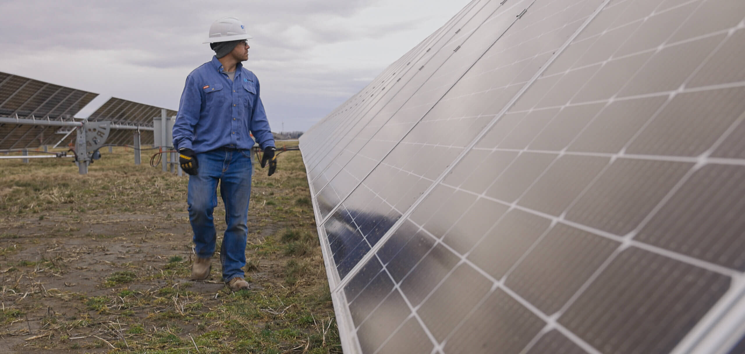 man walking next to solar panel